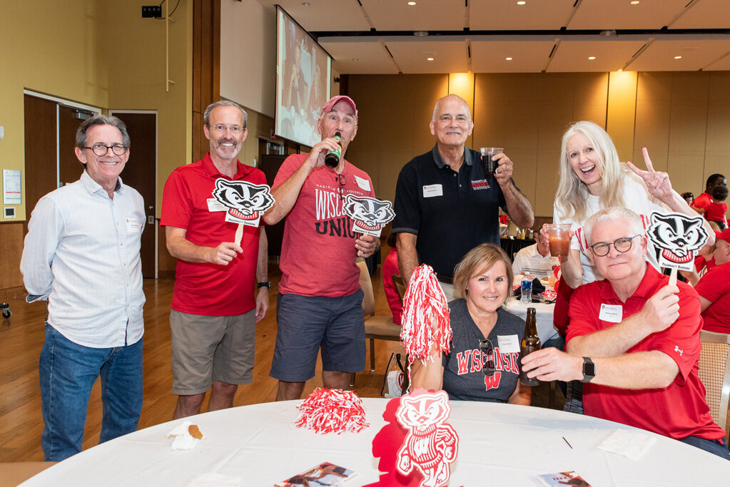 UWPharm-Tailgate_09172022_023 A group of alumni, including John Swann, Rick Bertz, and others, smile at the camera with Professor Paul Hutson and Associate Dean for Advancement Dave Mott.