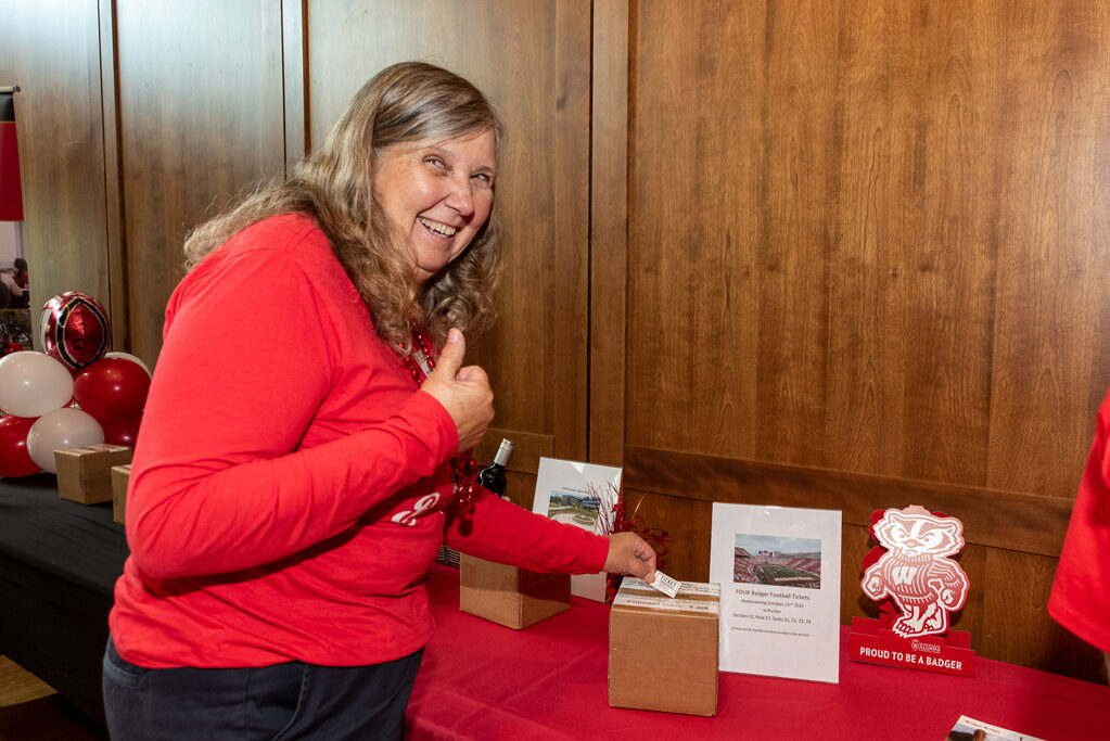UWPharm-Tailgate_09172022_026 An alumna gives a thumbs up as she bids on a raffle item.