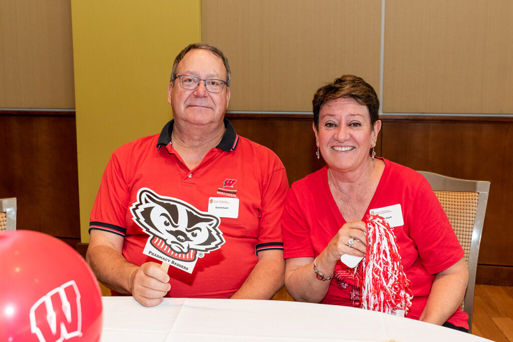 UWPharm-Tailgate_09172022_041 David and Mary Koch smile with Badger gear.