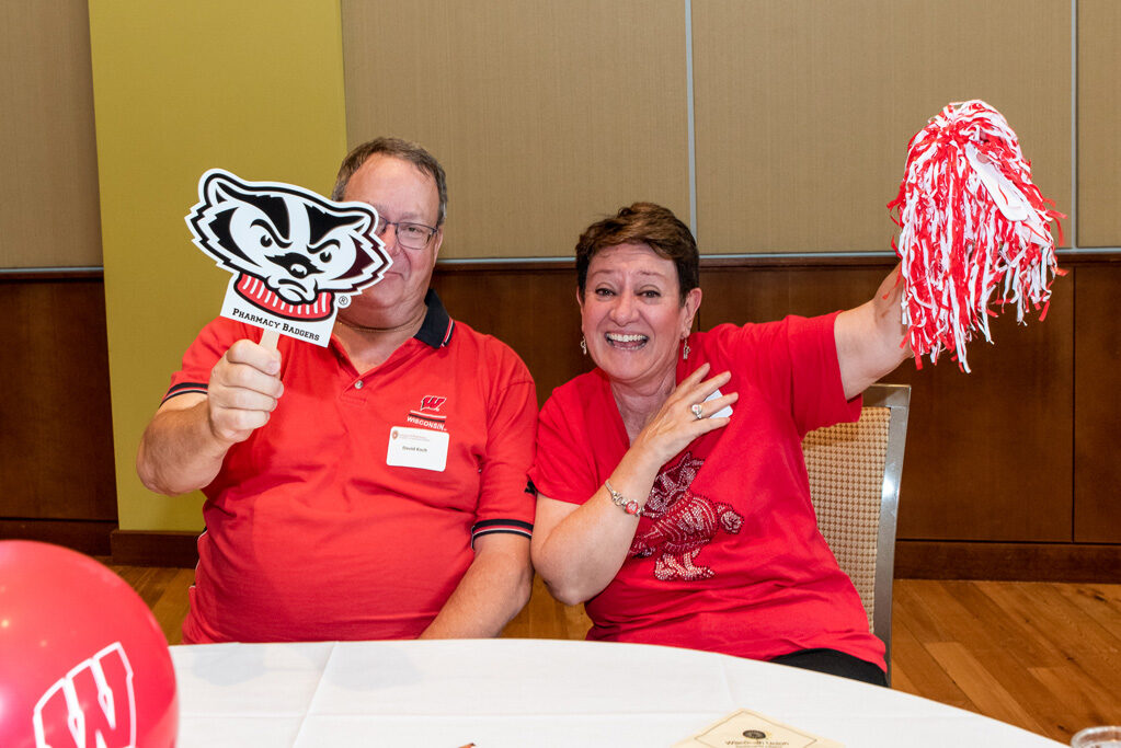 UWPharm-Tailgate_09172022_042 David and Mary Koch smile with Badger gear.