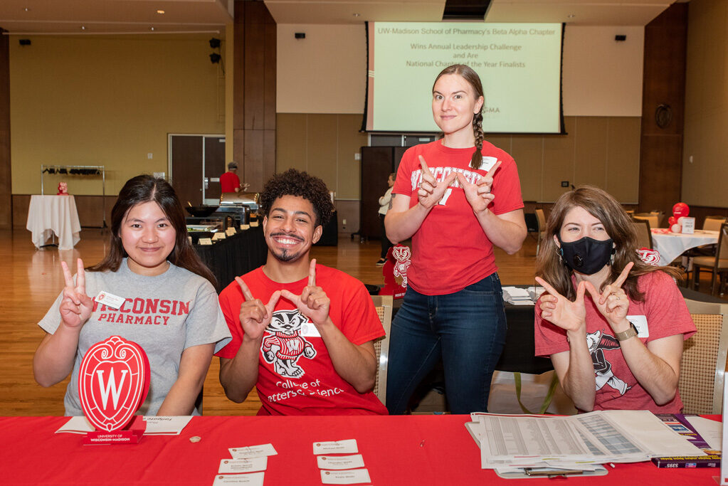 UWPharm-Tailgate_09172022_044 PharmD students Charisse Yan and Dyson Ahola smile with event coordinator Anna Reinhart and alumni relations coordinator Alissa Karnaky.