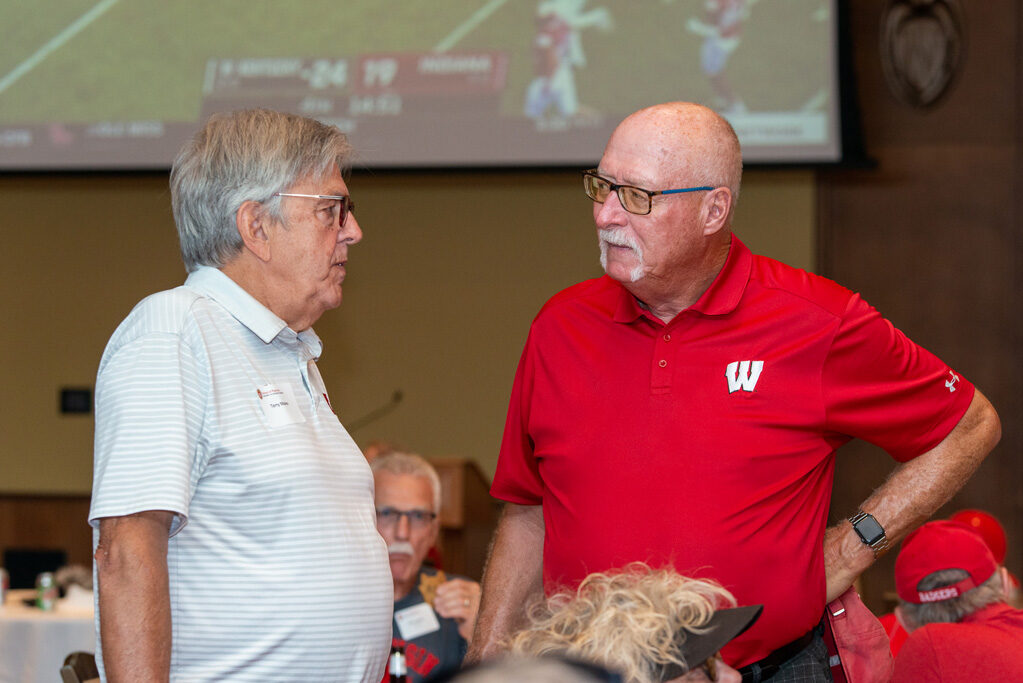 UWPharm-Tailgate_09172022_052 Two older male alumni speak during the viewing party.