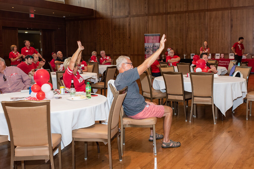 UWPharm-Tailgate_09172022_061 Alumni raise their hands as they win a raffle item.