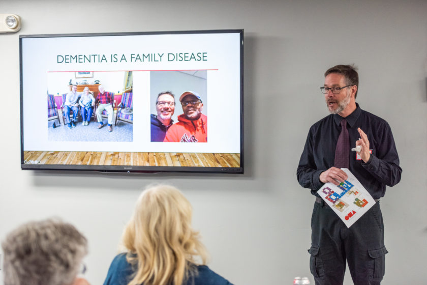 Presenter next to screen reading "Dementia is a Family Disease"