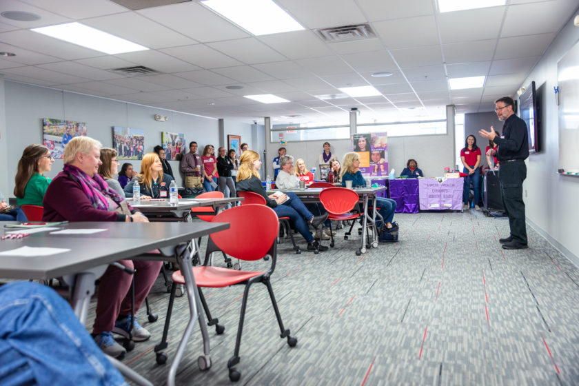 Panned out shot of entire room with coordinators and attendees for caregiver event