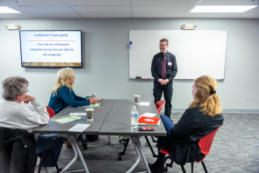Man speaking at front of room for caregiver training