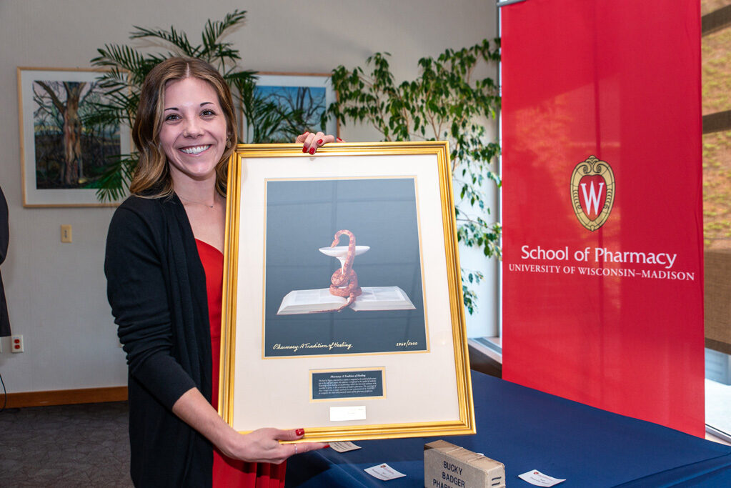 UWPhrmAward_2022_102 Graduate student holding up painting she received