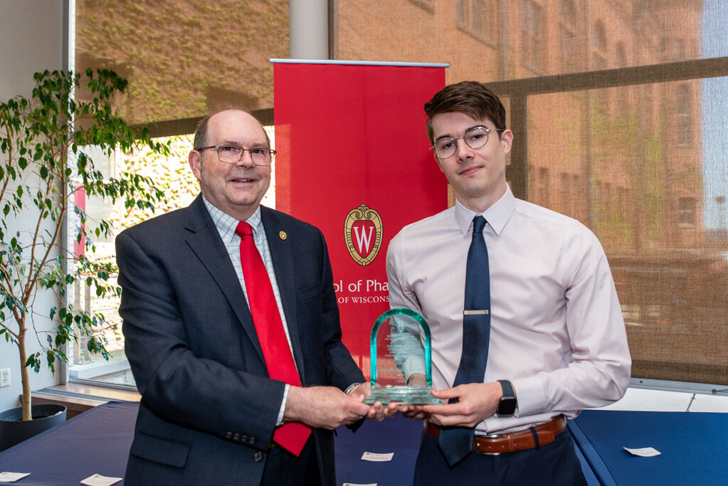 UWPhrmAward_2022_105 Faculty member and UW Pharm award recipient holding his award