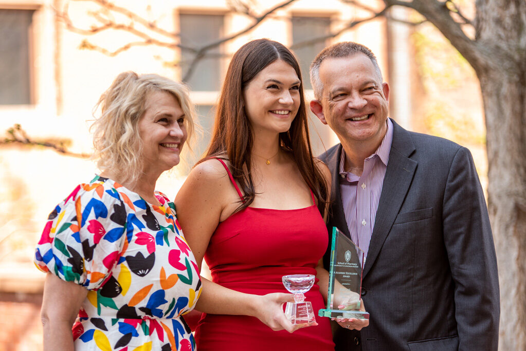 UWPhrmAward_2022_116 UW Pharm Award recipient holding her awards with her parents