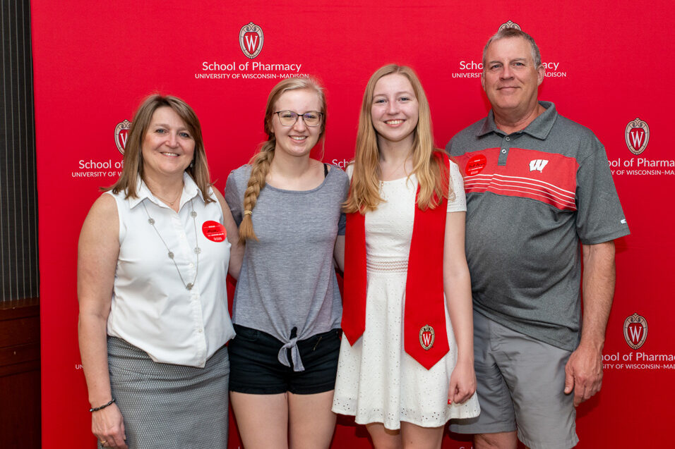 UWPhrmToxAw_2022_032 PharmTox student with family in front of red backdrop