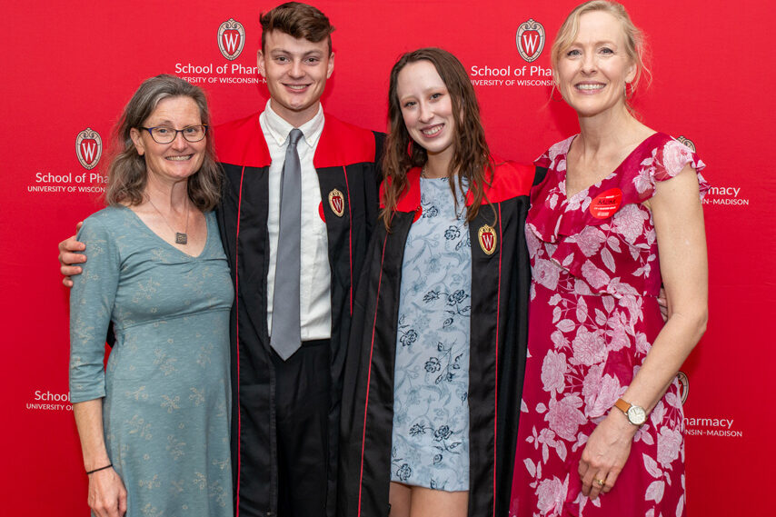 UWPhrmToxAw_2022_043 PharmTox students with their mothers in front of red backdrp