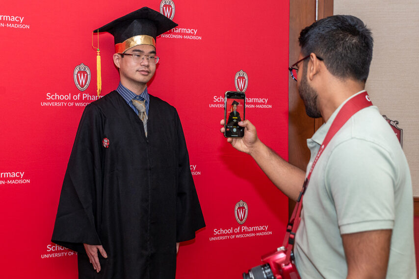UWPhrmToxAw_2022_185 Graduated student in front of red backdrop