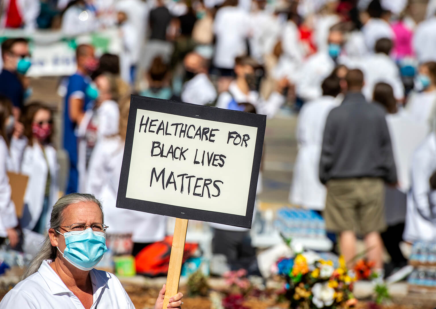 WC4BL_0620_DSC1906 Woman in white coat holding up sign reading "Healthcare for Black Lives Matters"