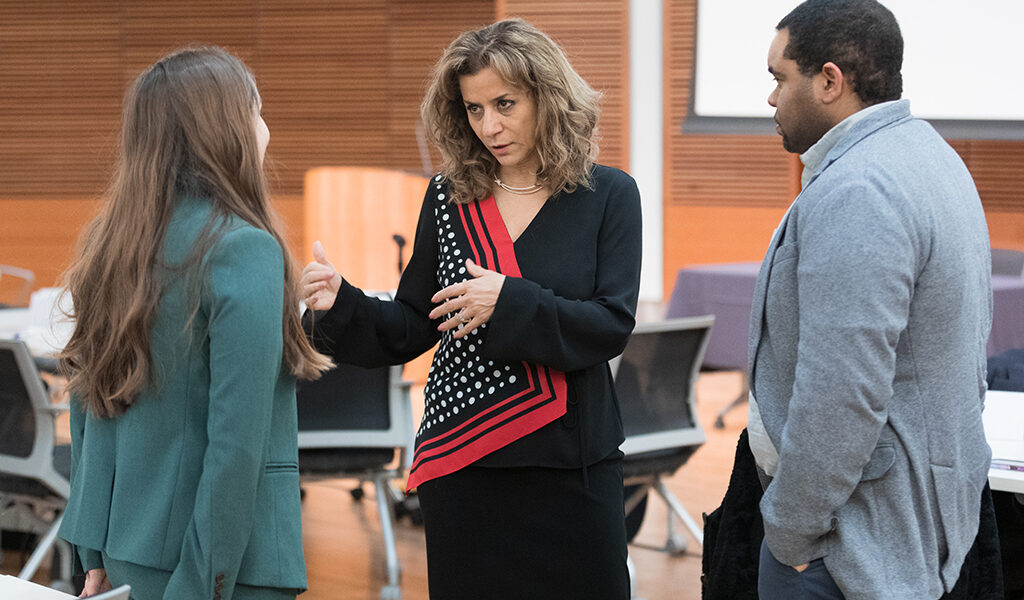 Azita Saleki Gerhardt speaks with two attendees