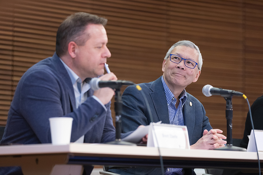 Brett Eberle and Roger Tung listen to a student presentation