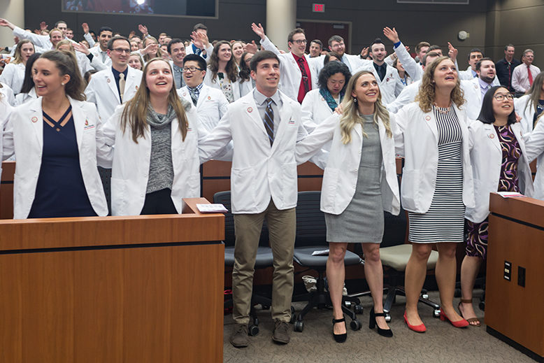phar050219_066 Student pharmacists locking arms during the ceremony