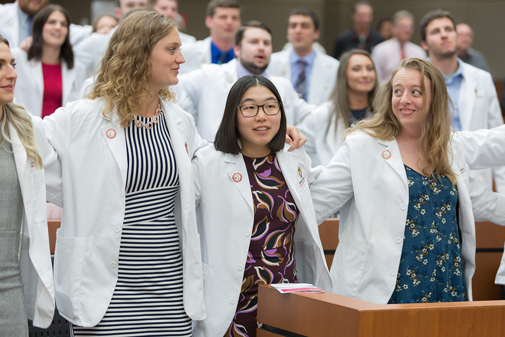phar050219_070 Student pharmacists locking arms during the ceremony