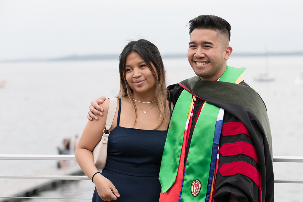 A School of Pharmacy graduate poses with a young woman.