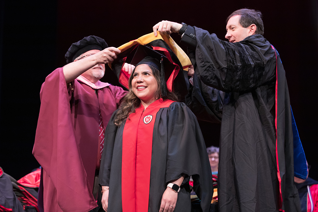 Assistant Dean Melgardt deVilliers and another professor putting the hood on a graduate student