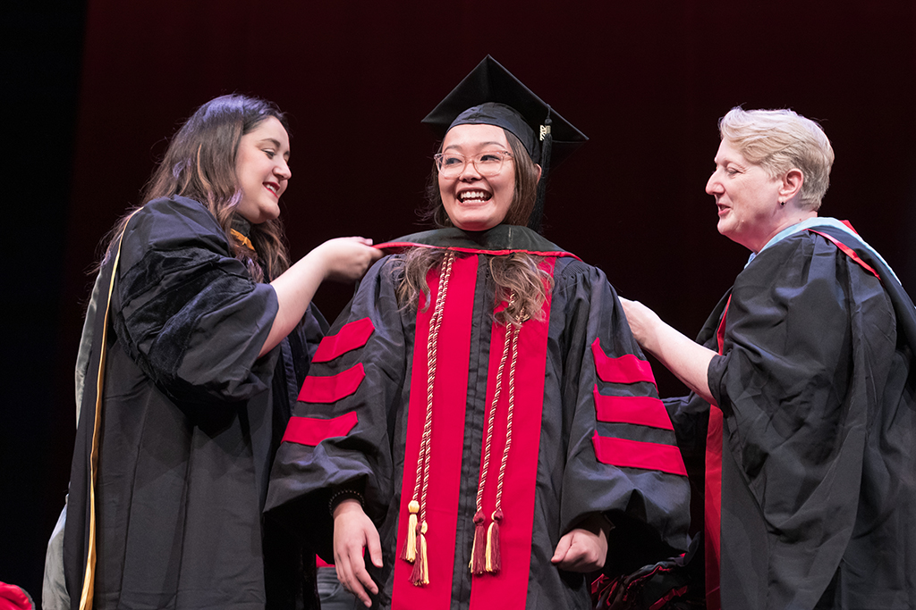 Class of 2022 PharmD graduate Lorewell Buaya receives her hood from Professors Marina Maes and Karen Kopacek