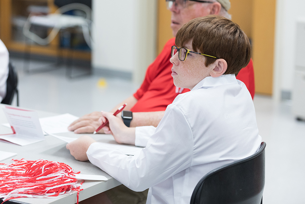 A young attendee listens to a speaker