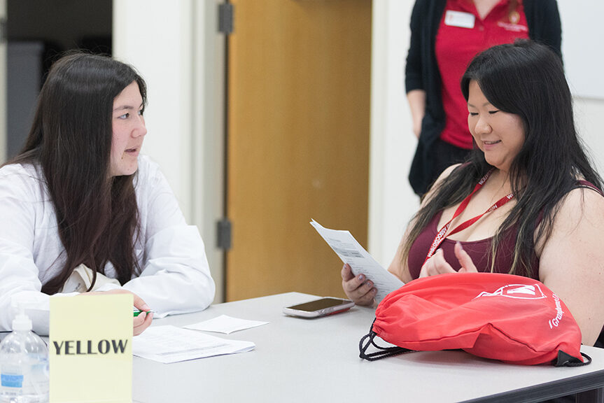 A pair of attendees discuss their worksheet