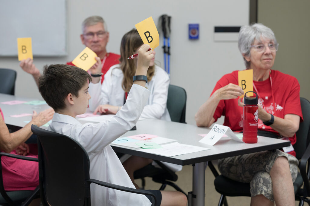 SoP Grandparents University 2023 Attendees hold up colored sheets with the letter B on them