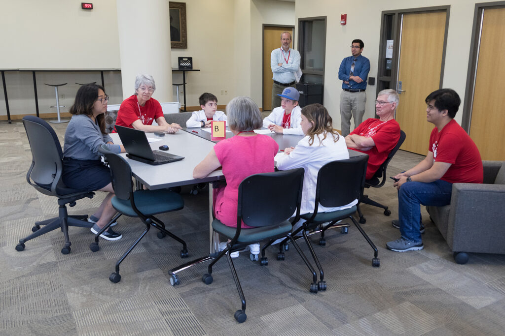 SoP Grandparents University 2023 Dave Mott and Ed Portillo look on as a table of attendees works together