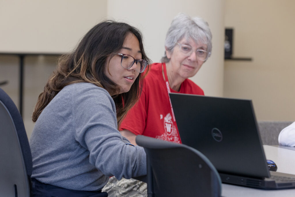 SoP Grandparents University 2023 One attendee gestures to a laptop to another older attendee