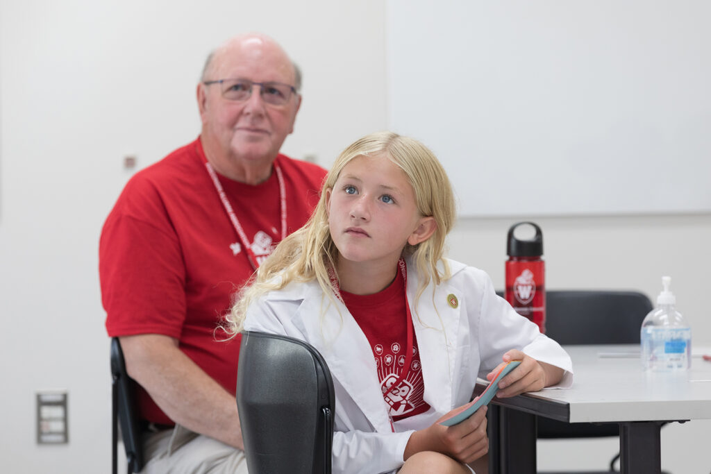 SoP Grandparents University 2023 A young attendee with an older attendee, listening to a presenter