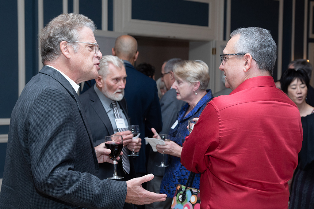 UW School of Pharmacy 2022 Citations of Merit Dinner & Awards Barry Gidal and Paul Marker speak in the foreground, while Ron Sorkness and Karen Kopacek speak in the background.