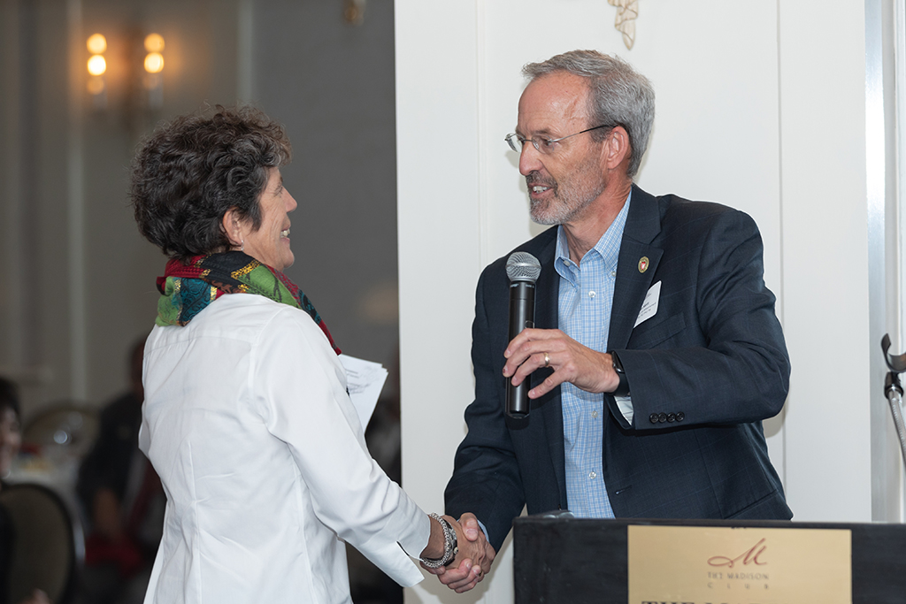 UW School of Pharmacy 2022 Citations of Merit Dinner & Awards Dave Mott and Susan Stein shaking hands.
