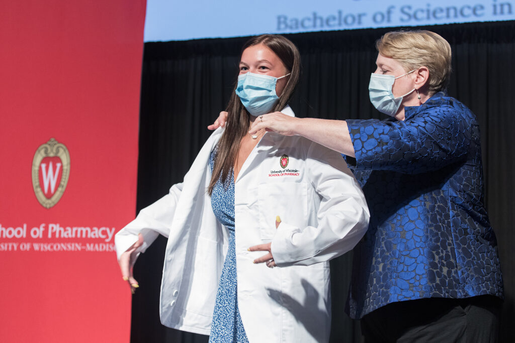 Student wearing their white coat on-stage