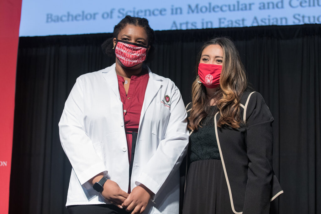 Student wearing their white coat on-stage