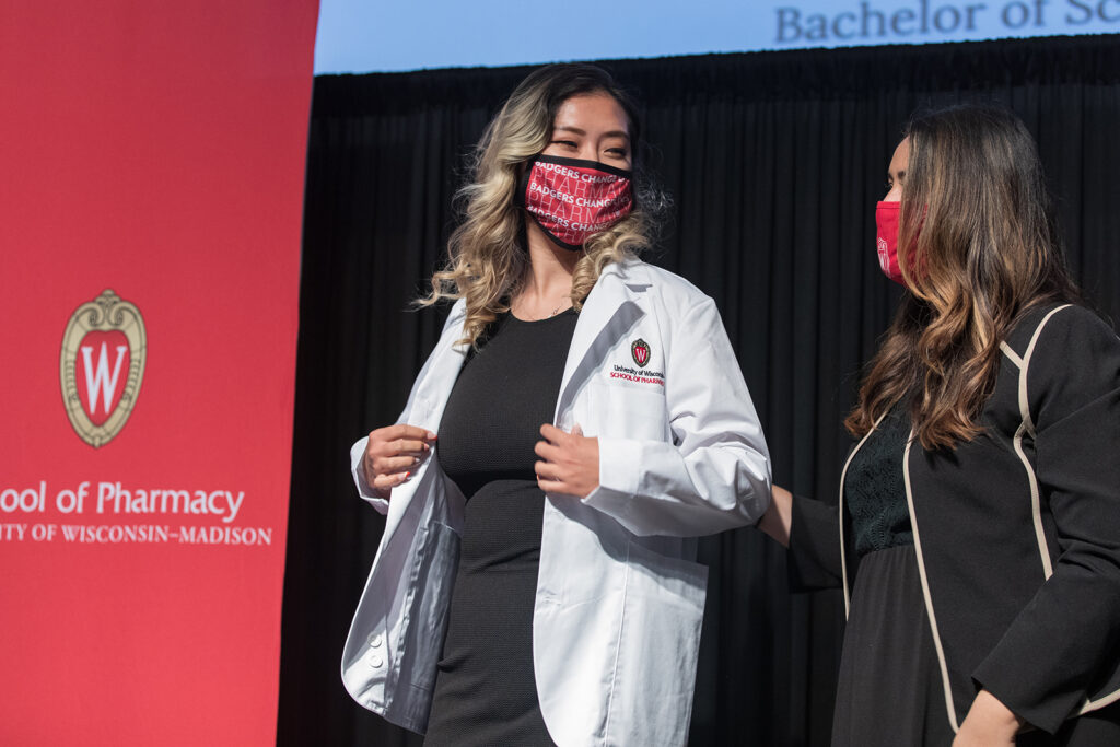 Student wearing their white coat on-stage
