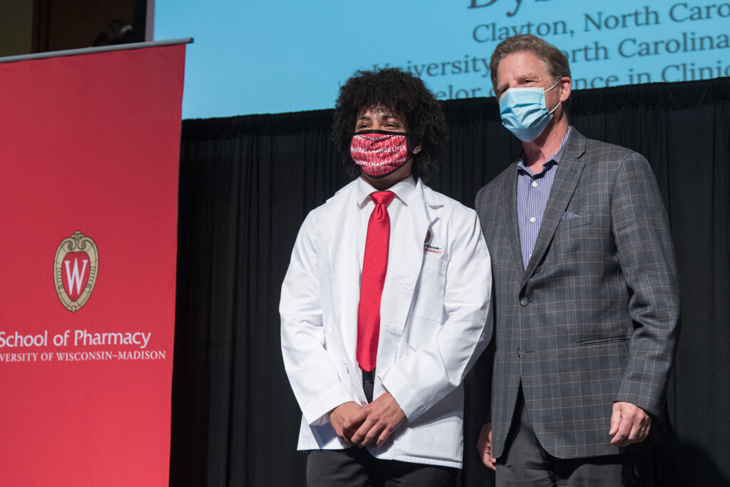 Student wearing their white coat on-stage