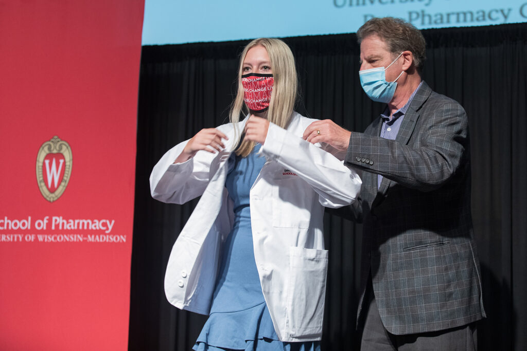 Student wearing their white coat on-stage