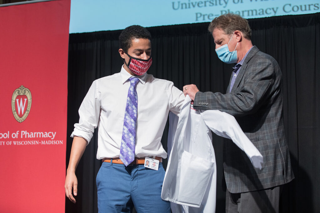 Student wearing their white coat on-stage