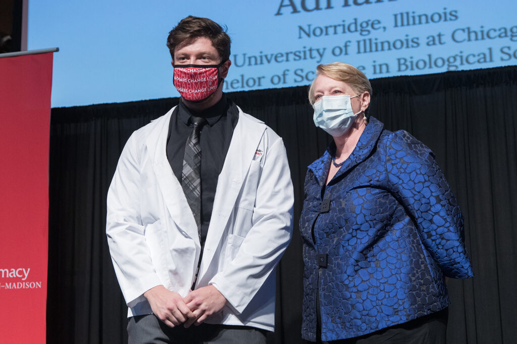 Student wearing their white coat on-stage