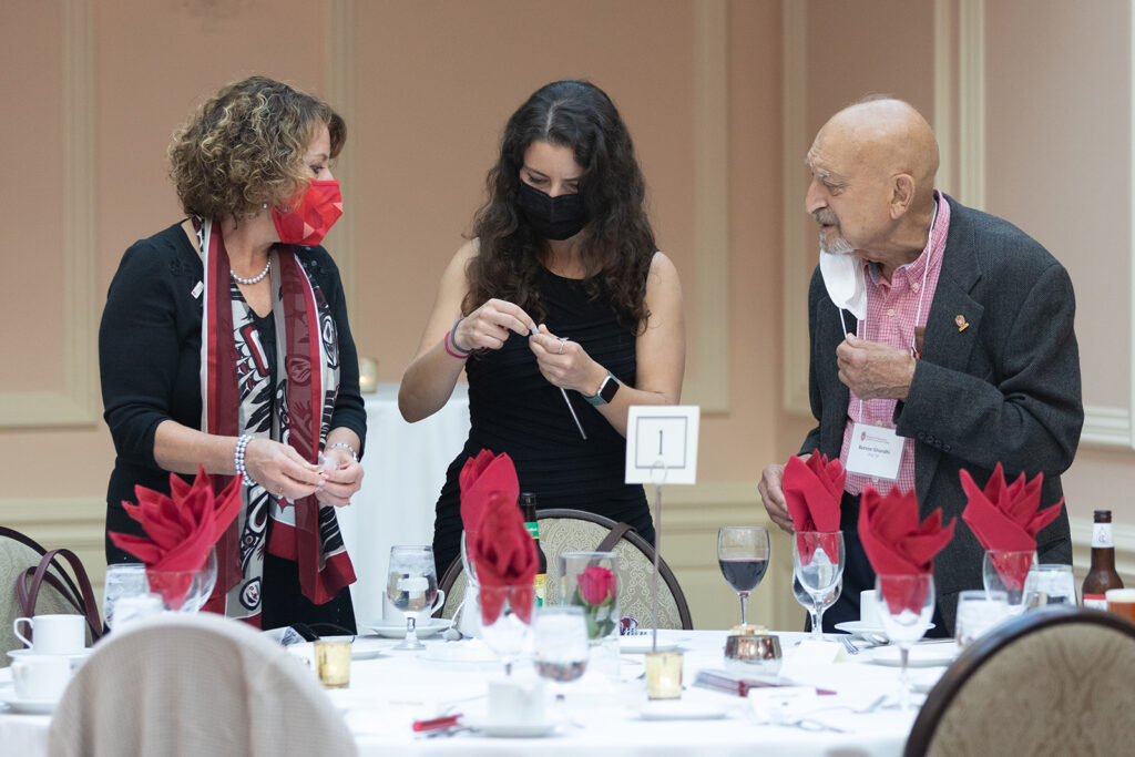 School of Pharmacy Citations of Merit Awards 2021 Event attendees gathered together with table filled with glasses in front of them