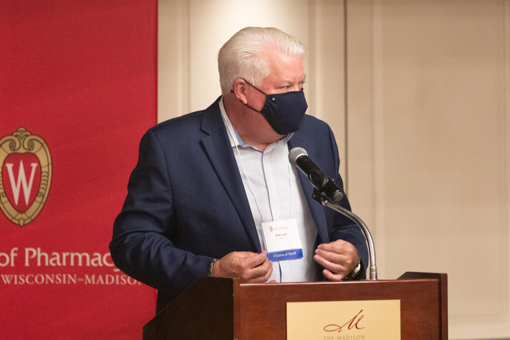 Dan Luce speaking at the podium