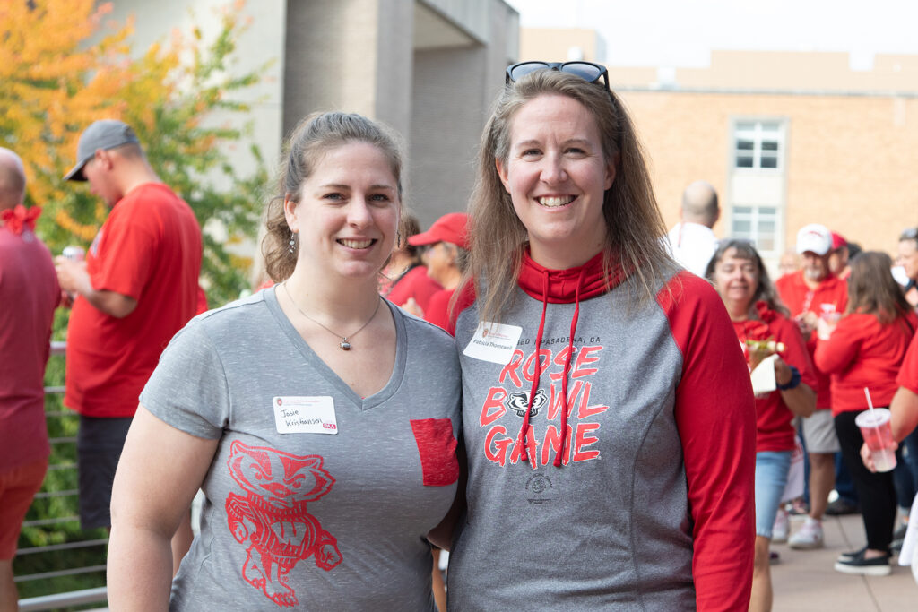 School of Pharmacy Alumni Tailgate Party 2021 Two alumni standing arm-in-arm