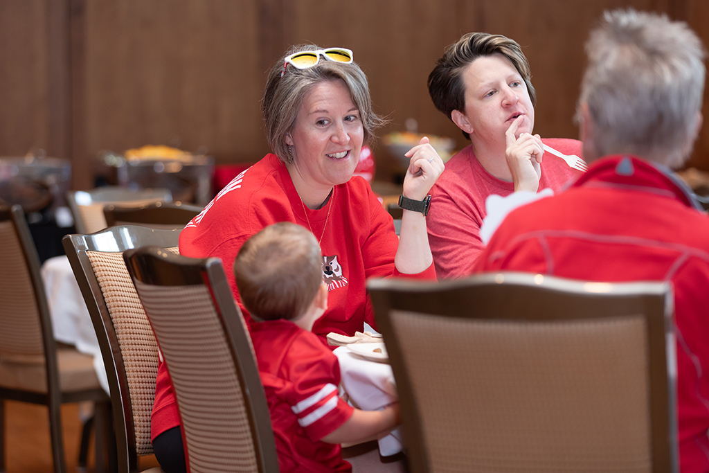 UW–Madison School of Pharmacy 2024 Alumni Tailgate and Watch Party Patti Thornwell speaks to her toddler at a table.