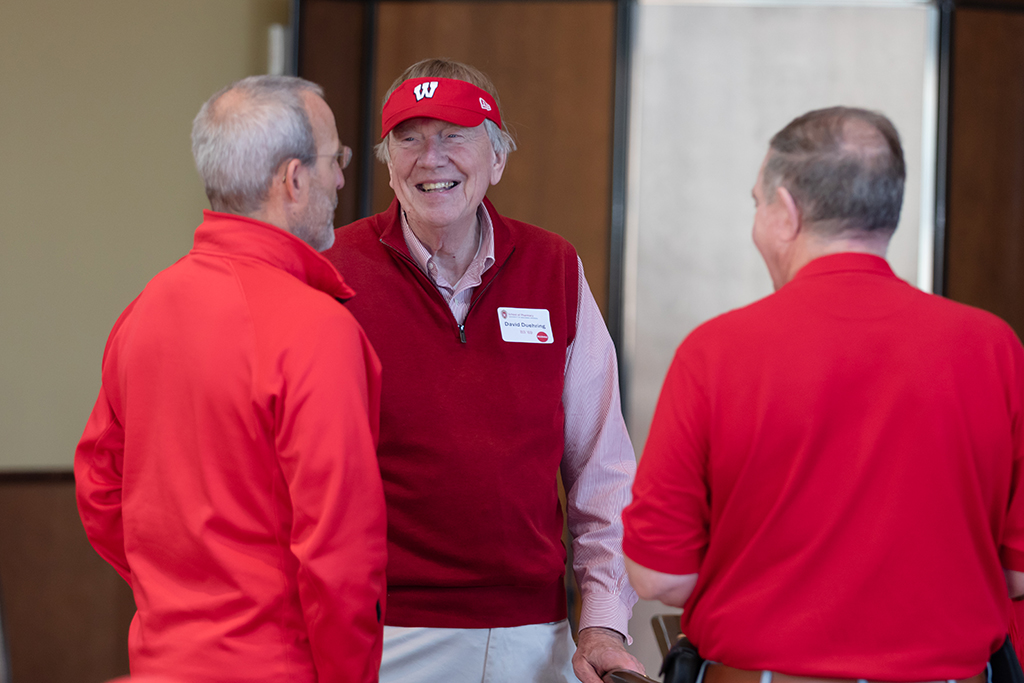 UW–Madison School of Pharmacy 2024 Alumni Tailgate and Watch Party David Duehring smiles in conversation with Dave Mott and Russ Jensen