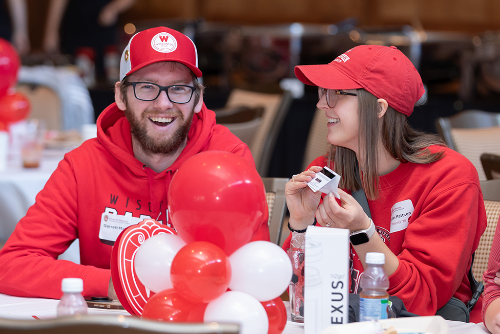UW–Madison School of Pharmacy 2024 Alumni Tailgate and Watch Party Garret and Jordan Mattson smile during the raffle