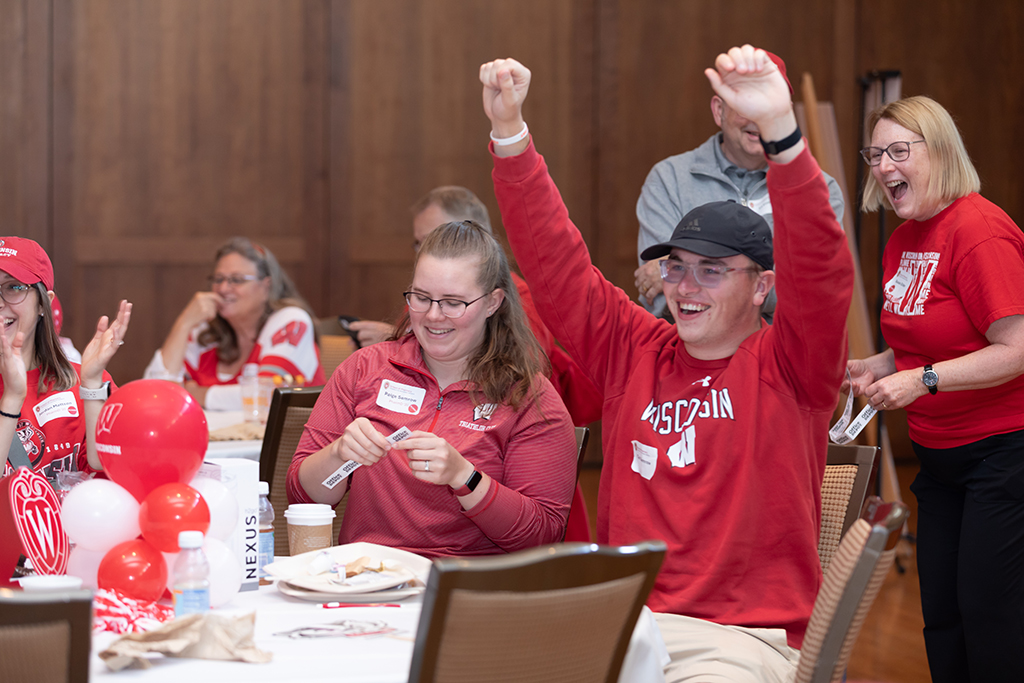 UW–Madison School of Pharmacy 2024 Alumni Tailgate and Watch Party Paige Semrow looks at a raffle ticket while her husband excitedly raises his hands