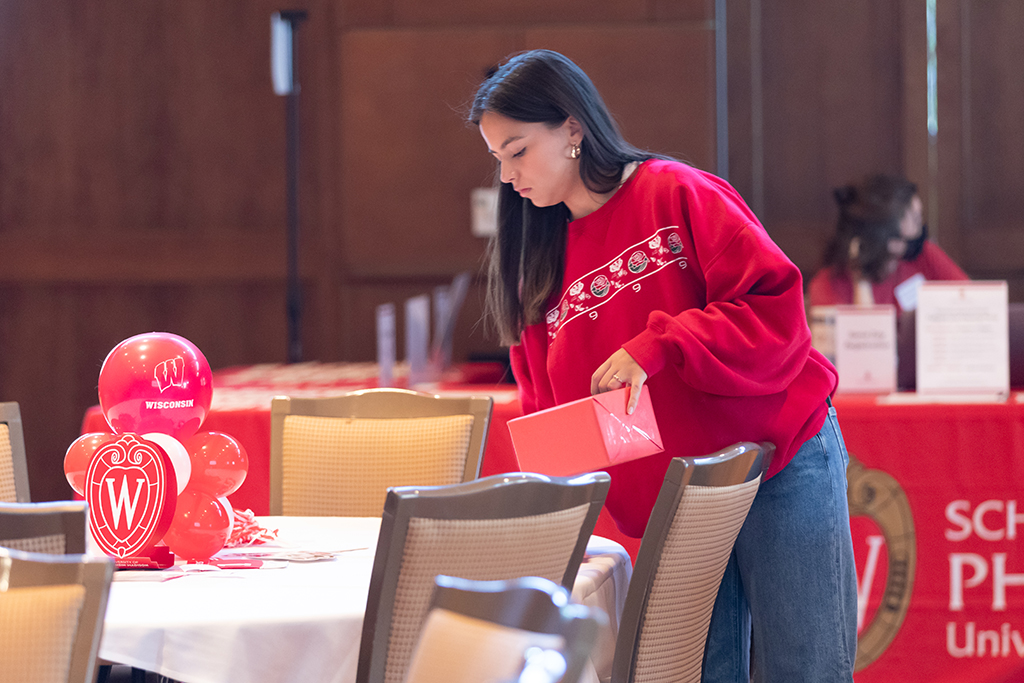 UW–Madison School of Pharmacy 2024 Alumni Tailgate and Watch Party A student places materials on one of the tables