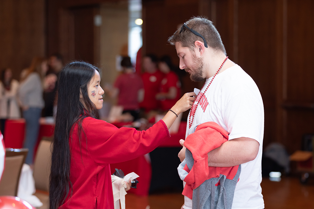 UW–Madison School of Pharmacy 2024 Alumni Tailgate and Watch Party Stephaney Cheng puts a name tag on another attendee