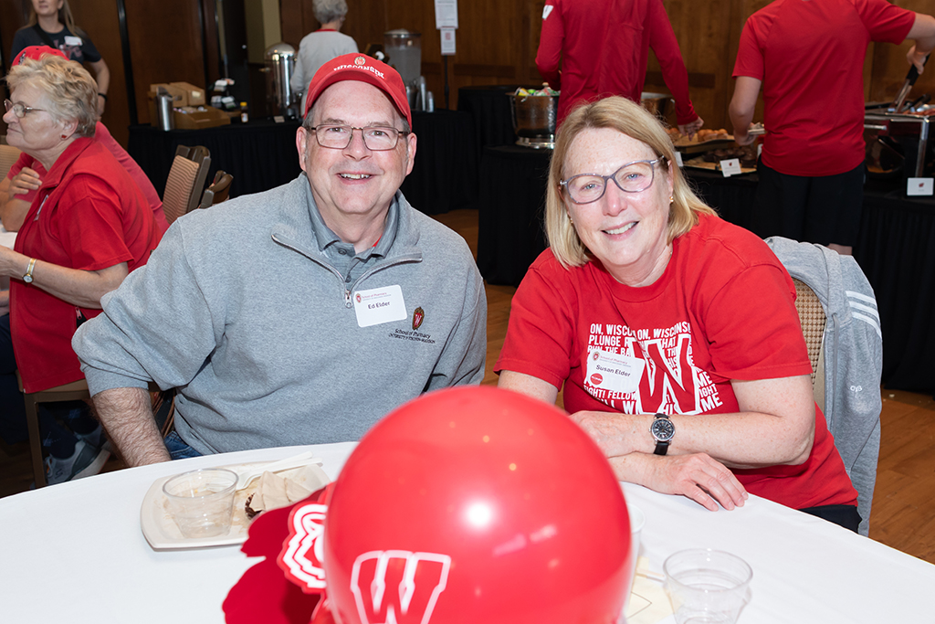 UW–Madison School of Pharmacy 2024 Alumni Tailgate and Watch Party Ed and Susan Elder smile for a photo while seated at a table