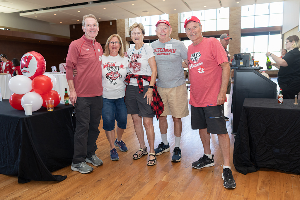 UW–Madison School of Pharmacy 2024 Alumni Tailgate and Watch Party Cynthia and James Steffen, Mary and Jay Rice, and another attendee smile for a photo